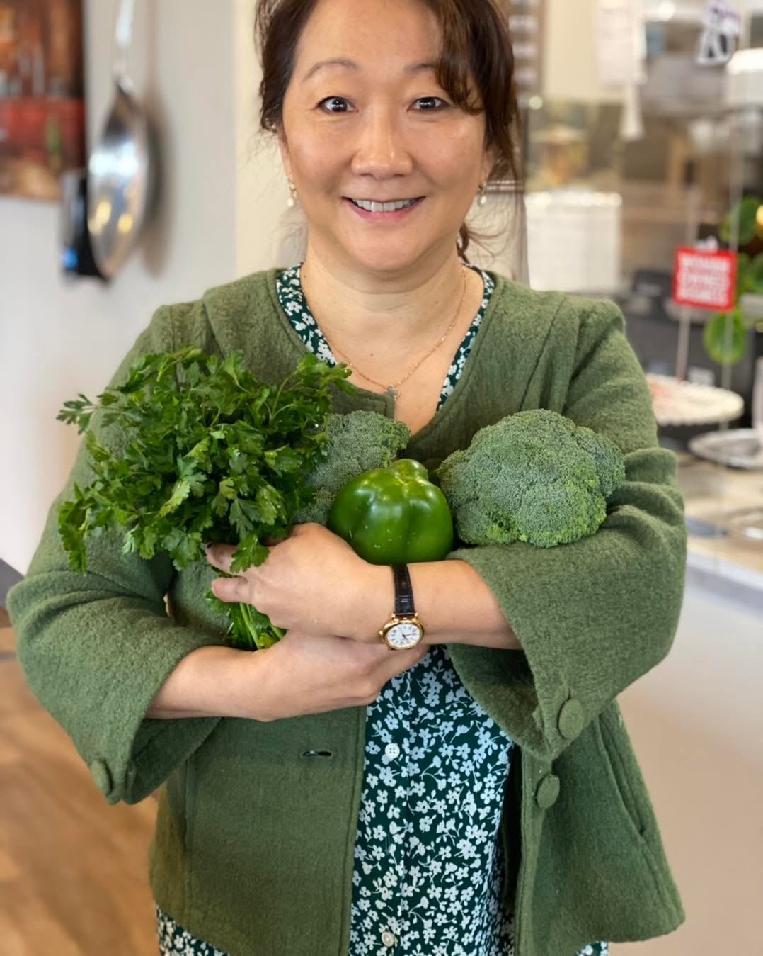 Sue holding fresh vegetables at Airport Cafe PDX